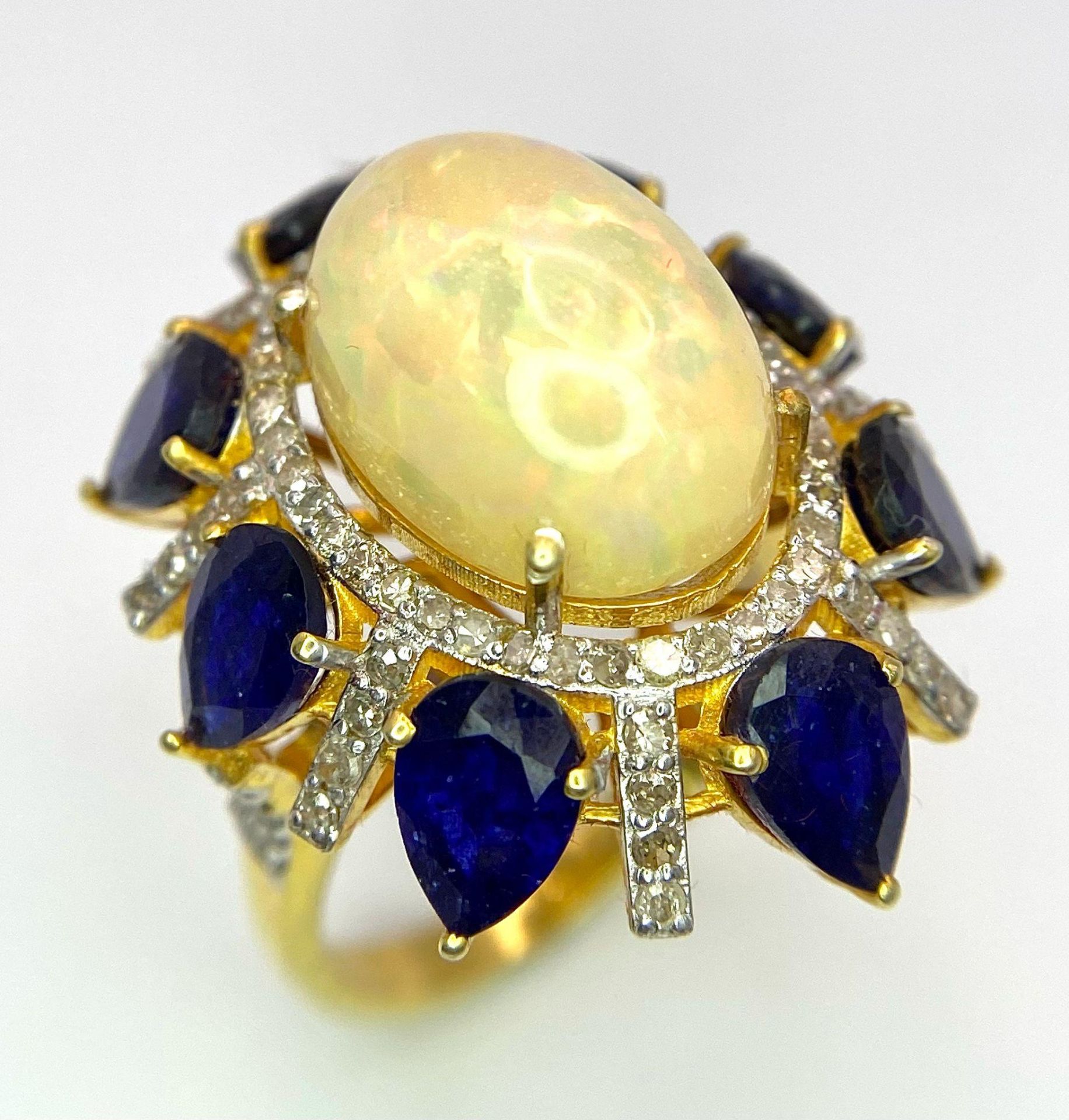 A Head-Turning Opal, Tanzanite and Diamond Ring. Centre 7ct colour-play opal with a tanzanite and