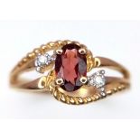 A 10k Yellow Gold Garnet and Diamond Crossover Ring. Size L. 1.86g weight.