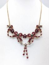 An Art Deco Style 9K Yellow Gold Ruby and Diamond Lavaliere Necklace. Floral and bow decoration.