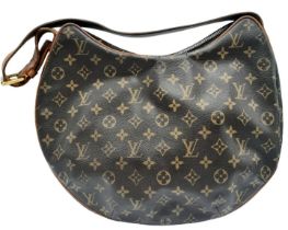 A Louise Vuitton Monogram Croissant GM with Vachetta Leather Trim and Strap. Gold Tone Hardware.