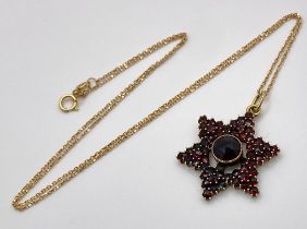 A 14K Gold and Garnet Star Pendant on an 18K Yellow Gold Disappearing Necklace. 3cm and 44cm.4.5g