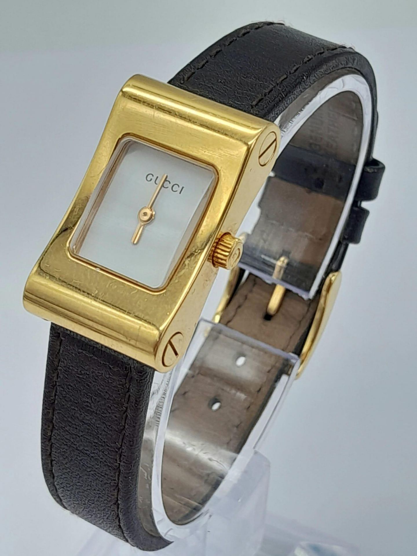 A Gucci 2300L Quartz Ladies Watch. Brown leather strap. Gilded case - 17mm. White dial. In need of a