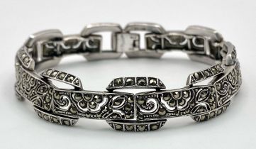 A vintage, sterling silver bracelet, with an elaborate filigree design studded with marcasite.