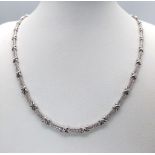 An 18K White Gold and Diamond Bar Link Necklace. 1.24ctw of diamonds. Love-knot separators. 43cm