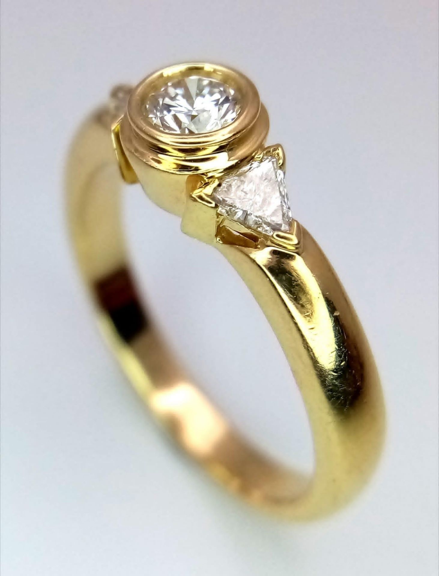 An 18K Yellow Gold Diamond Ring. Central round cut diamond with trillion cut diamond accents. Size - Bild 3 aus 6