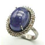 A 12ct Tanzanite Cabochon Gemstone ring with a 1.2ctw Double Diamond Halo. Set in 925 silver. Size