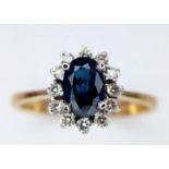 A 14K Yellow Gold Diamond and Sapphire Ring. Central oval cut sapphire with a diamond surround. Size