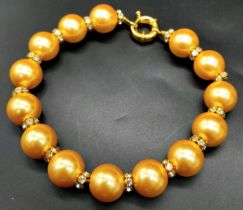 A Golden South Sea Pearl Shell Bracelet - White stone spacers. 18cm length. 12mm beads.