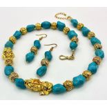 A glamorous necklace and matching earrings set with turquoise nuggets, gold filled “Good Luck” beads