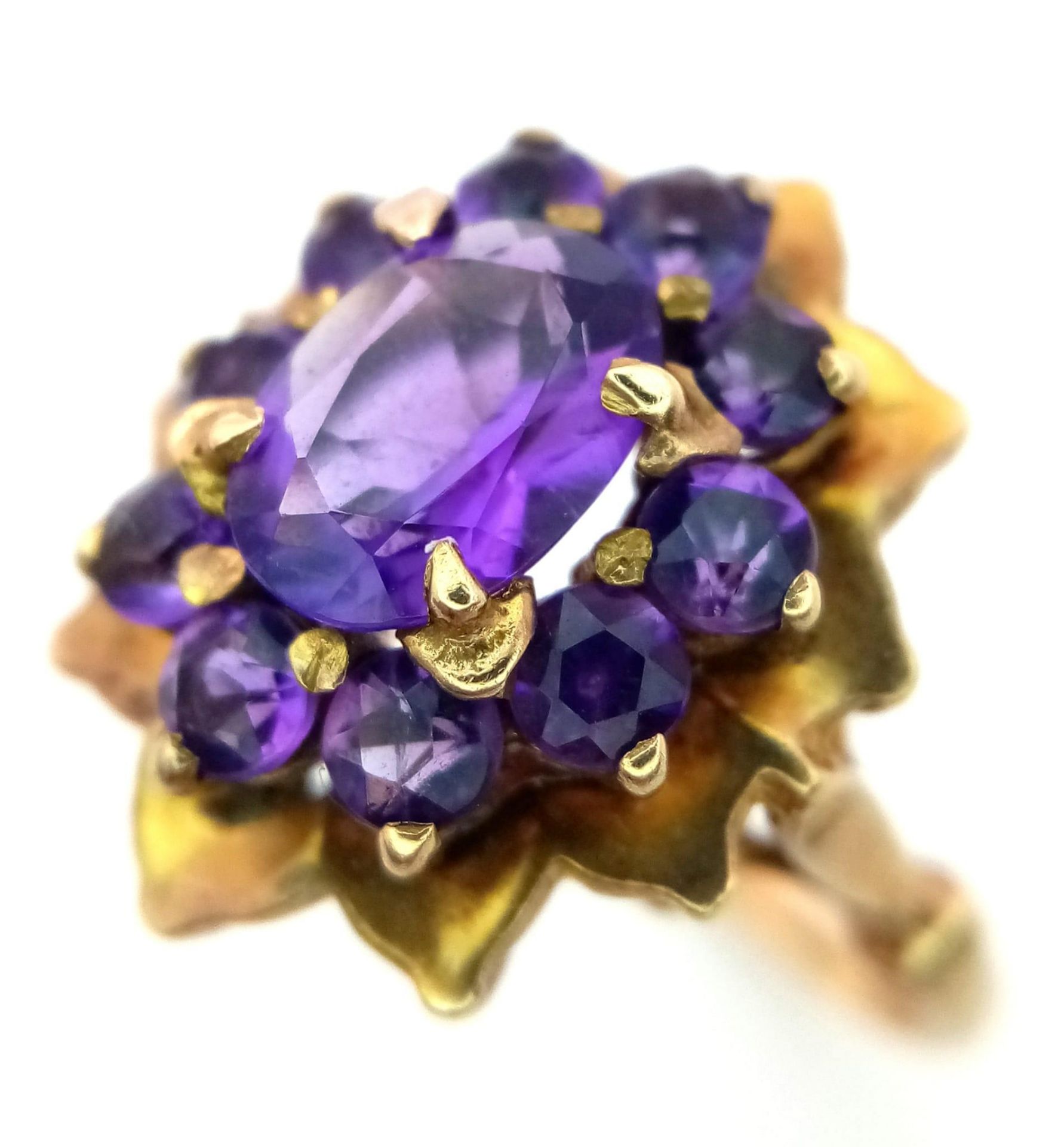 A Vintage 9K Yellow Gold Amethyst Ring. Central oval cut amethyst with an amethyst halo. Size M. 4.