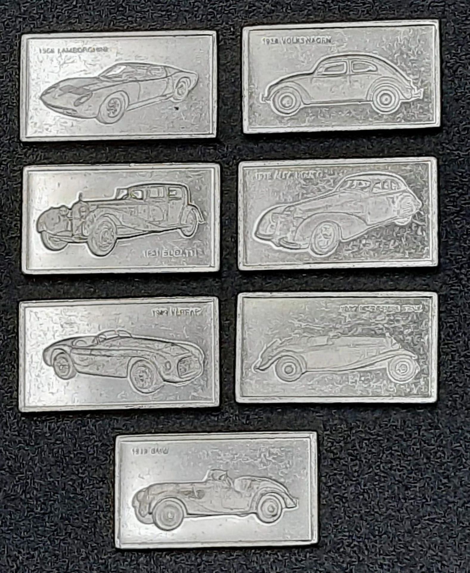 A SELECTION OF 7 EUROPEAN CAR MANUFACTURERS MIN CAR PLAQUES WITH LOGO ON ONE SIDE AND CAR AND
