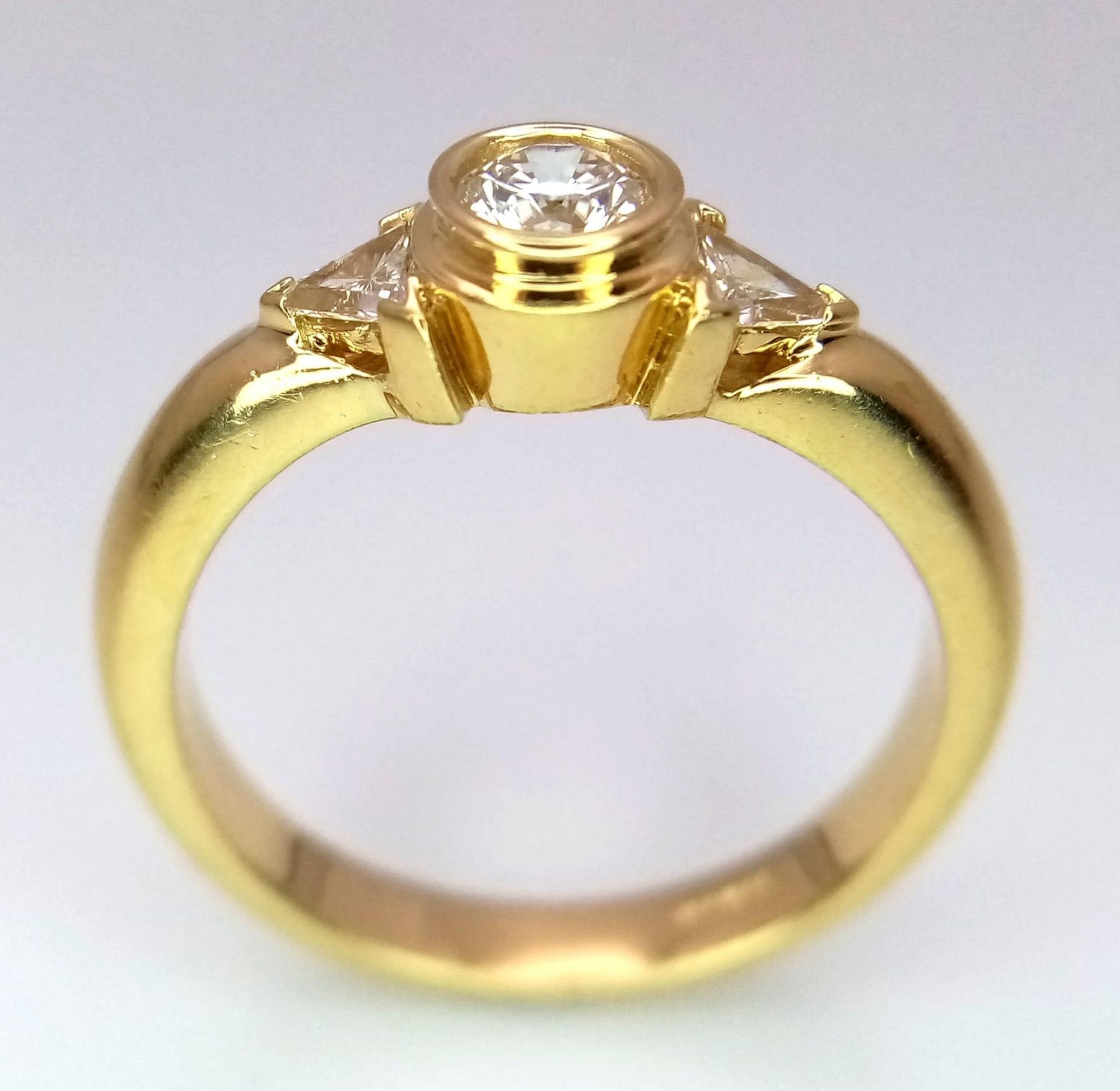 An 18K Yellow Gold Diamond Ring. Central round cut diamond with trillion cut diamond accents. Size - Bild 4 aus 6