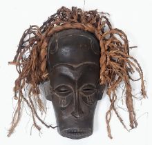 An antique Maasai wooden mask of a young warrior with red long “hair”. In very good condition for