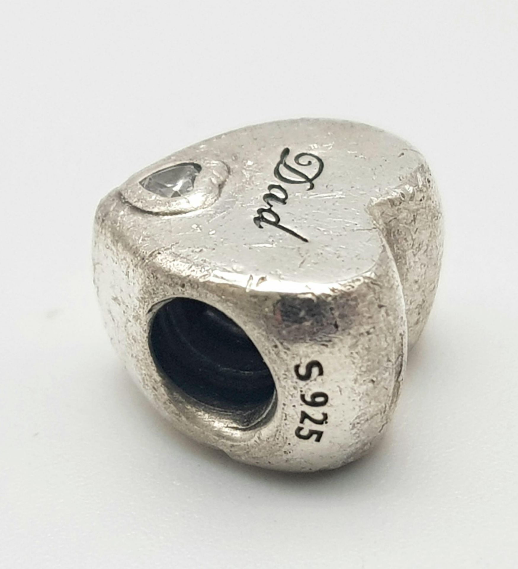 A PANDORA STERLING SILVER HEART SHAPED STONE SET CHARM, ENGRAVED WITH THE WORD "DAD" 3.9G ref: SC - Image 3 of 7