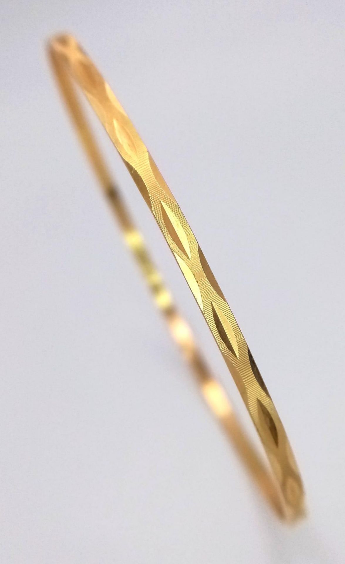 A 9K Yellow Gold Thin Bangle. 3mm width. 6.5cm inner diameter. 5.75g weight.