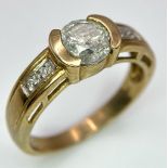 A Vintage 9K Yellow Gold Diamond Ring. Central 0.8ct diamond with winged diamond accents. Size O.
