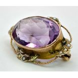 AN ANTIQUE EDWARDIAN AMETHYST BROOCH DECORATED WITH SEED PEARLS AND TWIST GOLDEN WIRE HALO . 8.7gms