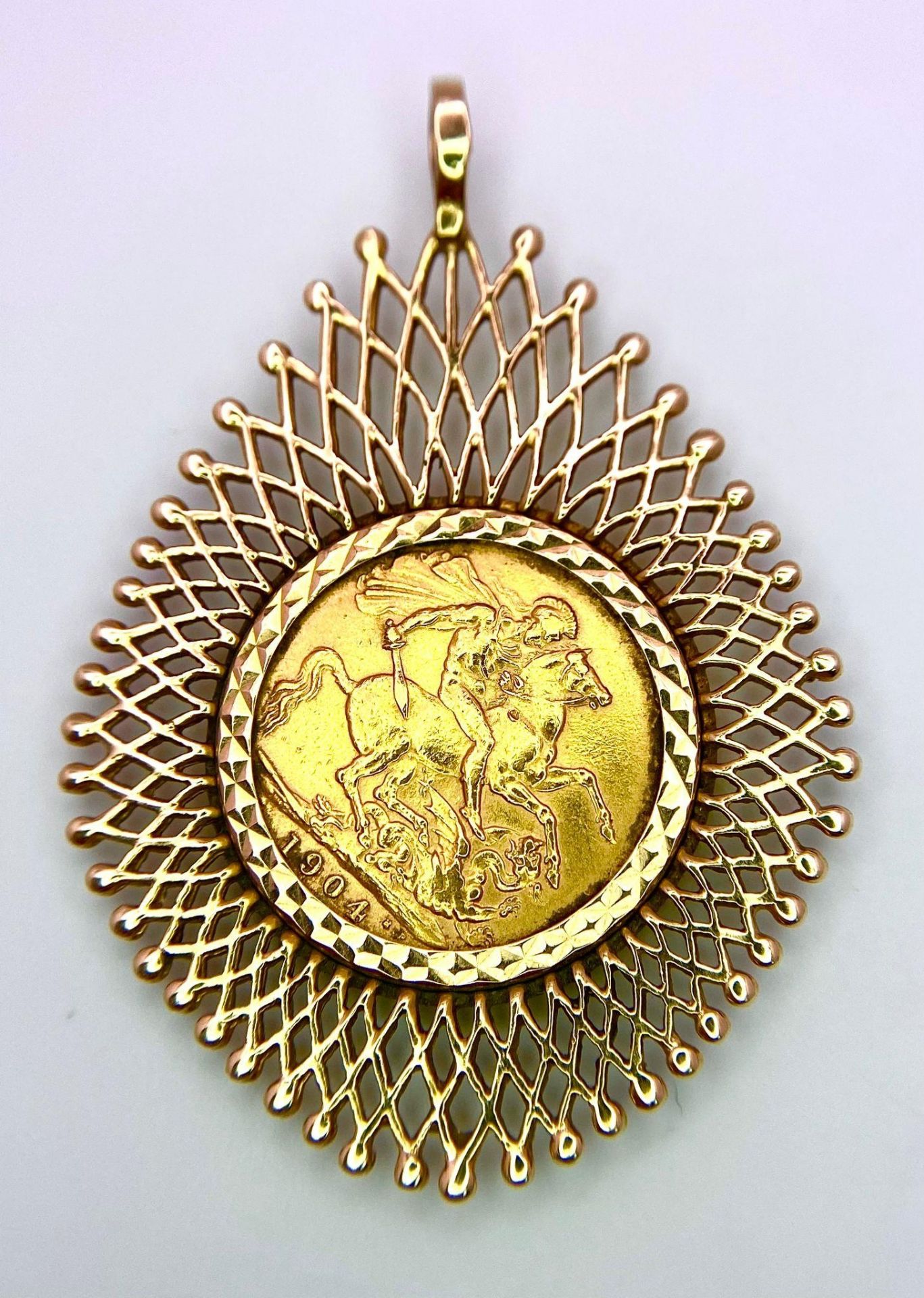 A 1904 SOVEREIGN COIN MOUNTED IN A 9K GOLD FILIGREE SETTING . 14.3gms