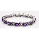 An Amethyst Gemstone Tennis Bracelet with Sapphire Spacers set in 925 Silver. 18cm length. 22.46g