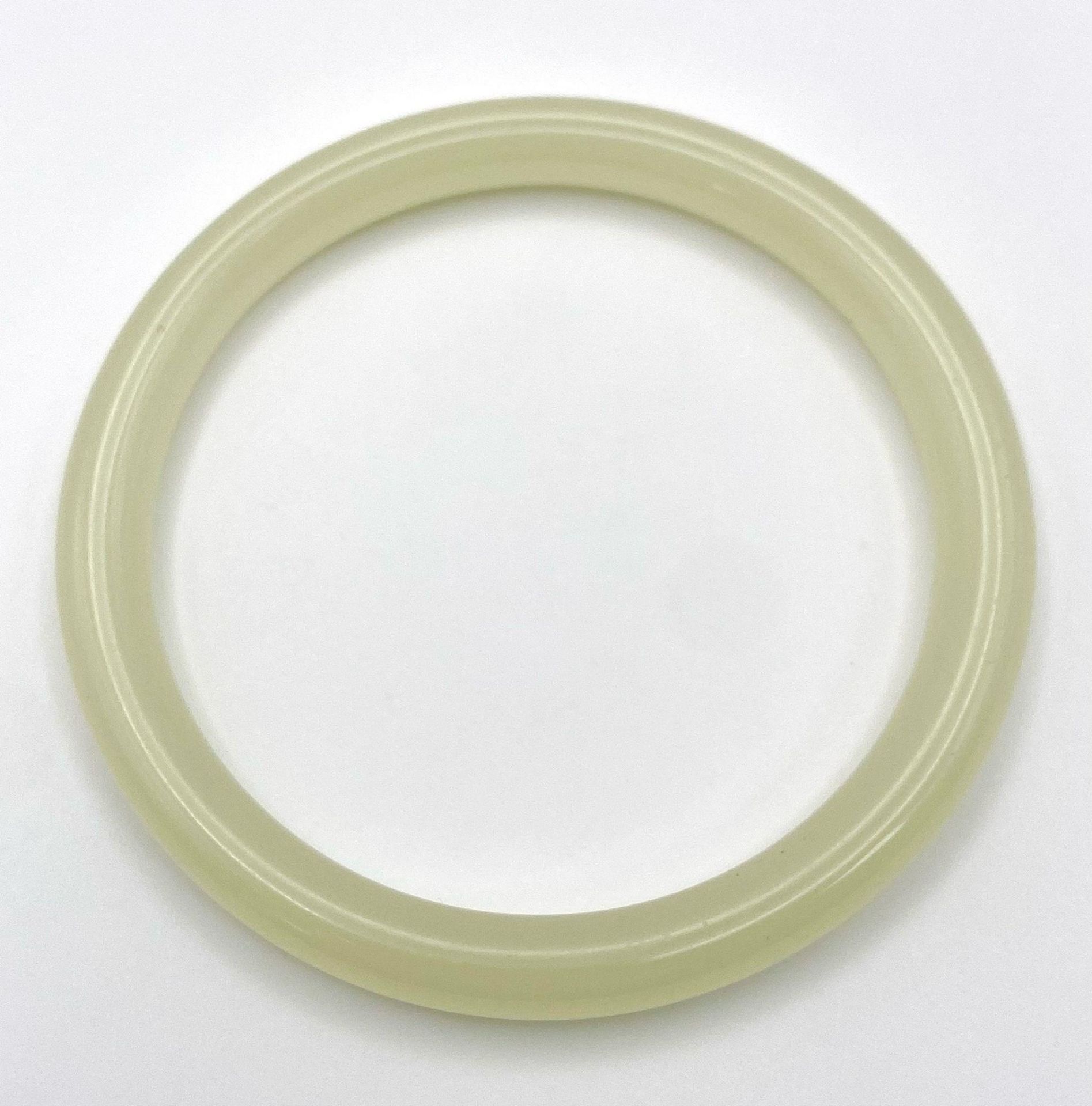 A Pale Green Thin Jade Bangle. 8mm width. 6cm inner diameter. - Image 2 of 3