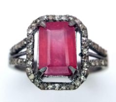 A Rectangular Shaped Ruby and Diamond Ring set in 925 gun-metal silver. Central ruby with diamond