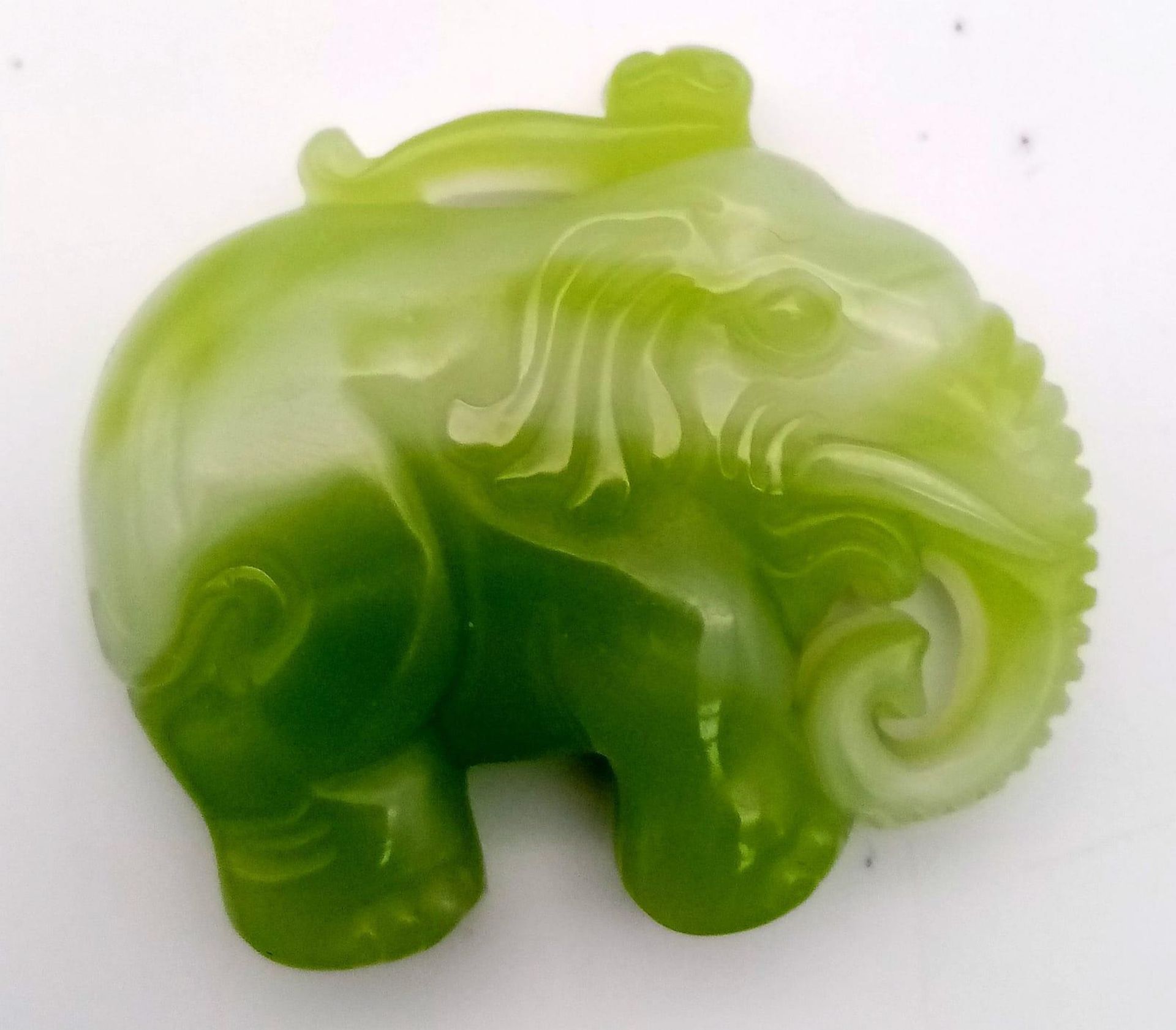 A Chinese Green and White Jade Elephant Pendant. 5 x 4.5cm.