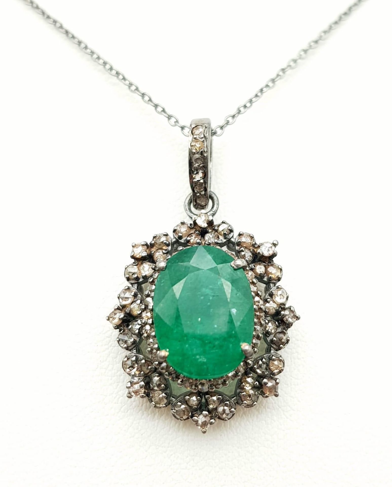 An Emerald Pendant with Diamond Surround on 925 Silver and Silver Chain. 6.90ct emerald, 1.25ctw