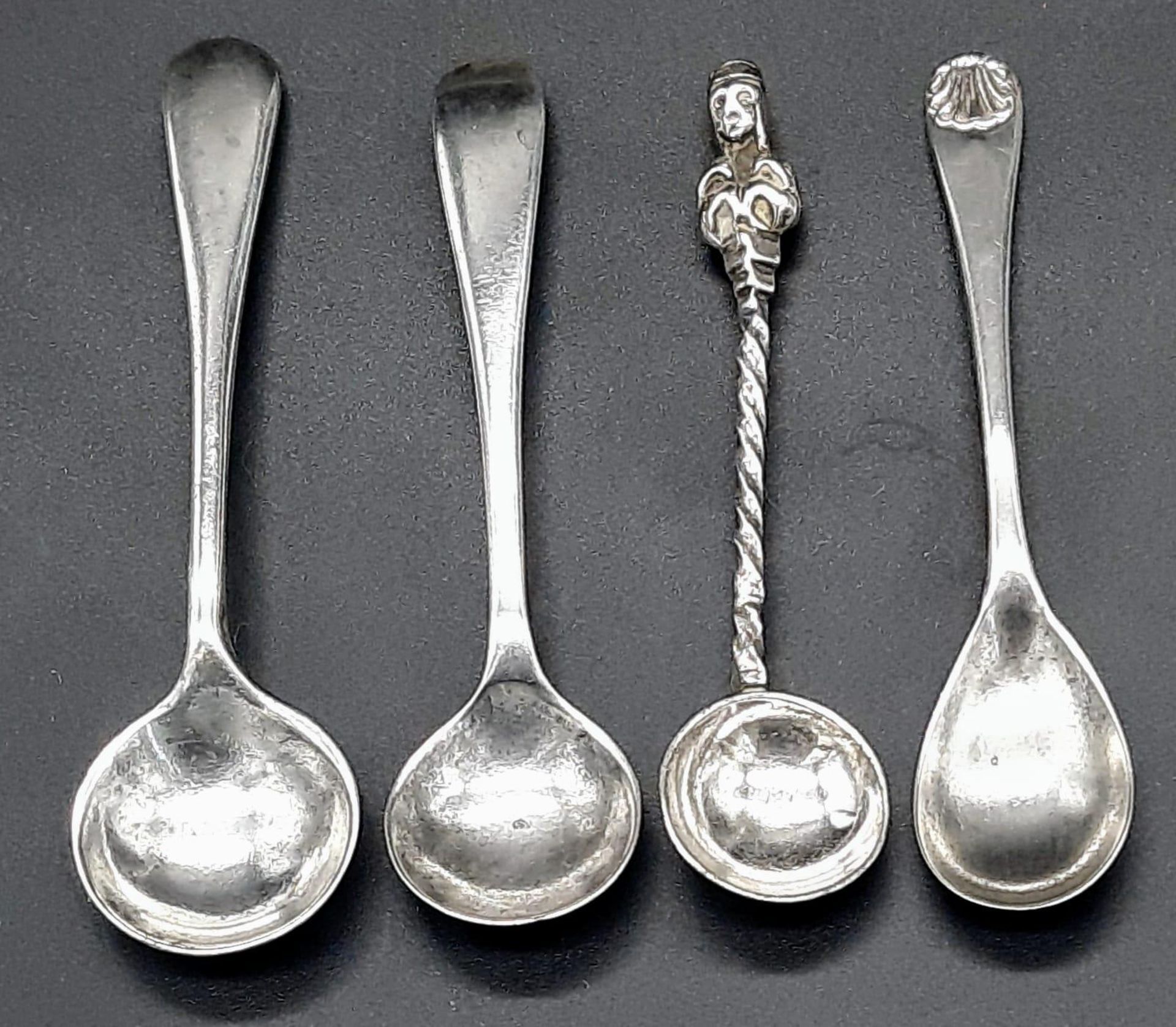 A collection of 4 antique sterling silver coffee spoons with various designs and lengths. 2 of