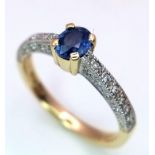 A 9K GOLD RING WITH CORNFLOWER BLUE OVAL SAPPHIRE AND DIAMOND SHOULDERS . 2.6gms size N