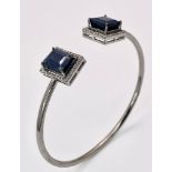 A Blue Sapphire and Diamond Cuff Bracelet. Blue Sapphire- 10.85ctw. Diamonds- 0.50ctw. Set in 925