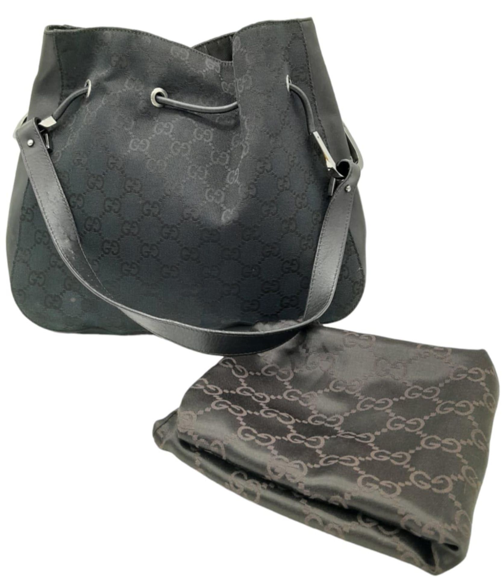 A Gucci Black Monogram Drawstring Shoulder Bag. Canvas exterior with silver-toned hardware,
