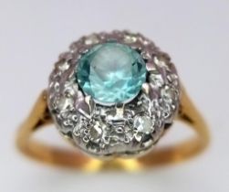 A Vintage 18K Yellow Gold Aquamarine and Diamond Ring. Central aquamarine with a diamond halo.