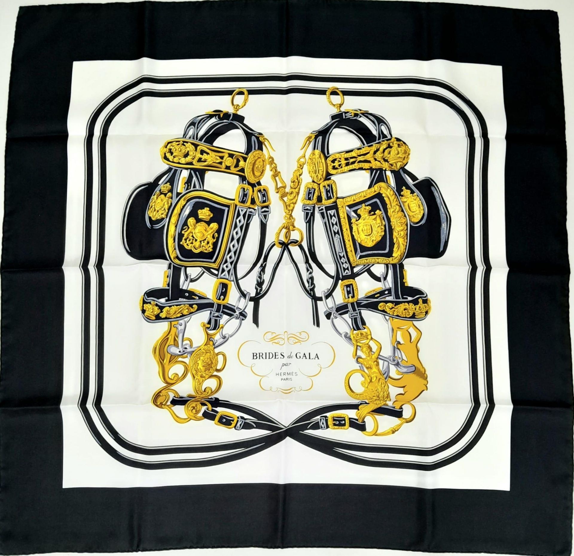 A Hermes Carre Silk Scarf "Brides de Gala" in Black, White and Gold Equestrian Print, features a