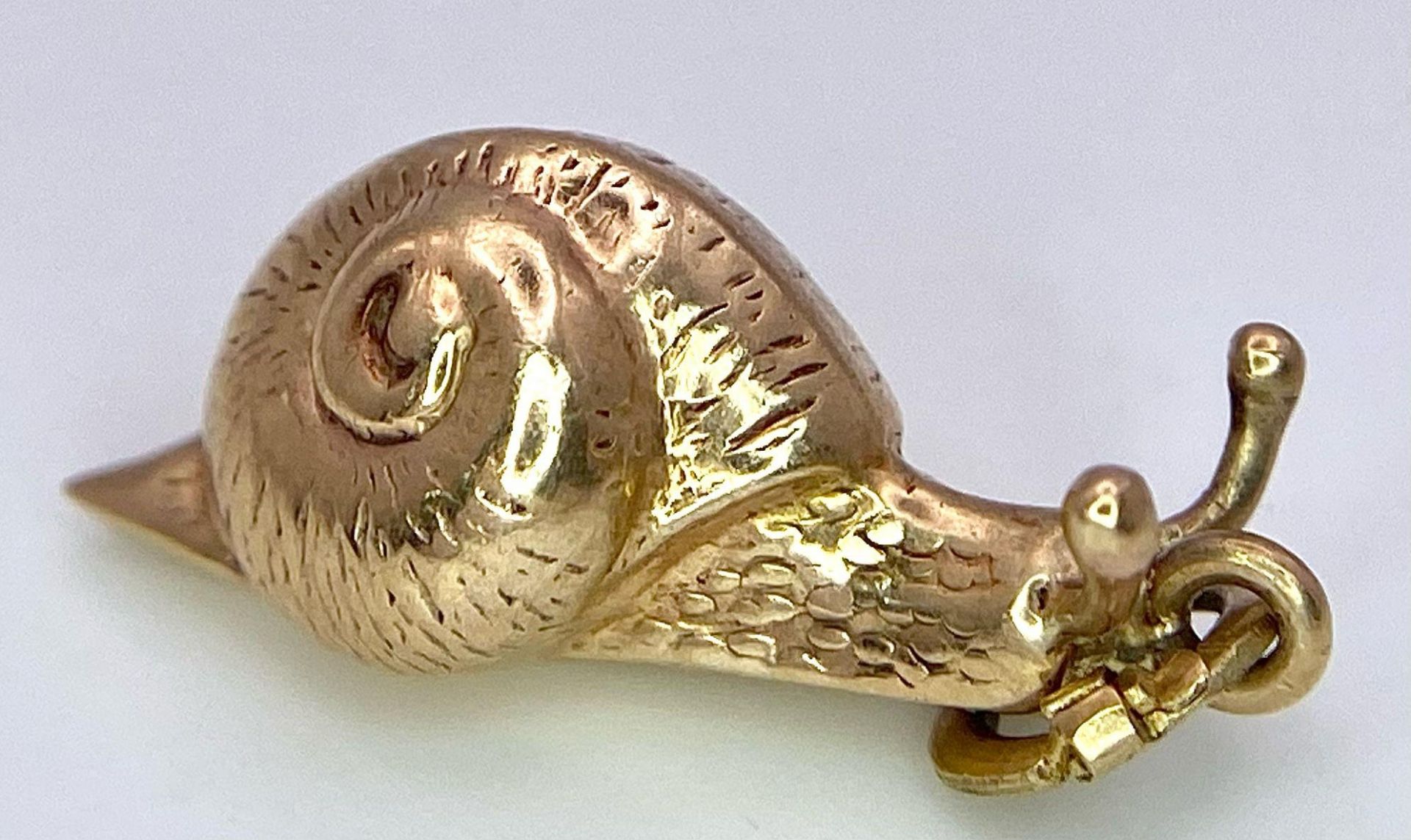 A 9K YELLOW GOLD SNAIL CHARM. TOTAL WEIGHT 0.8G