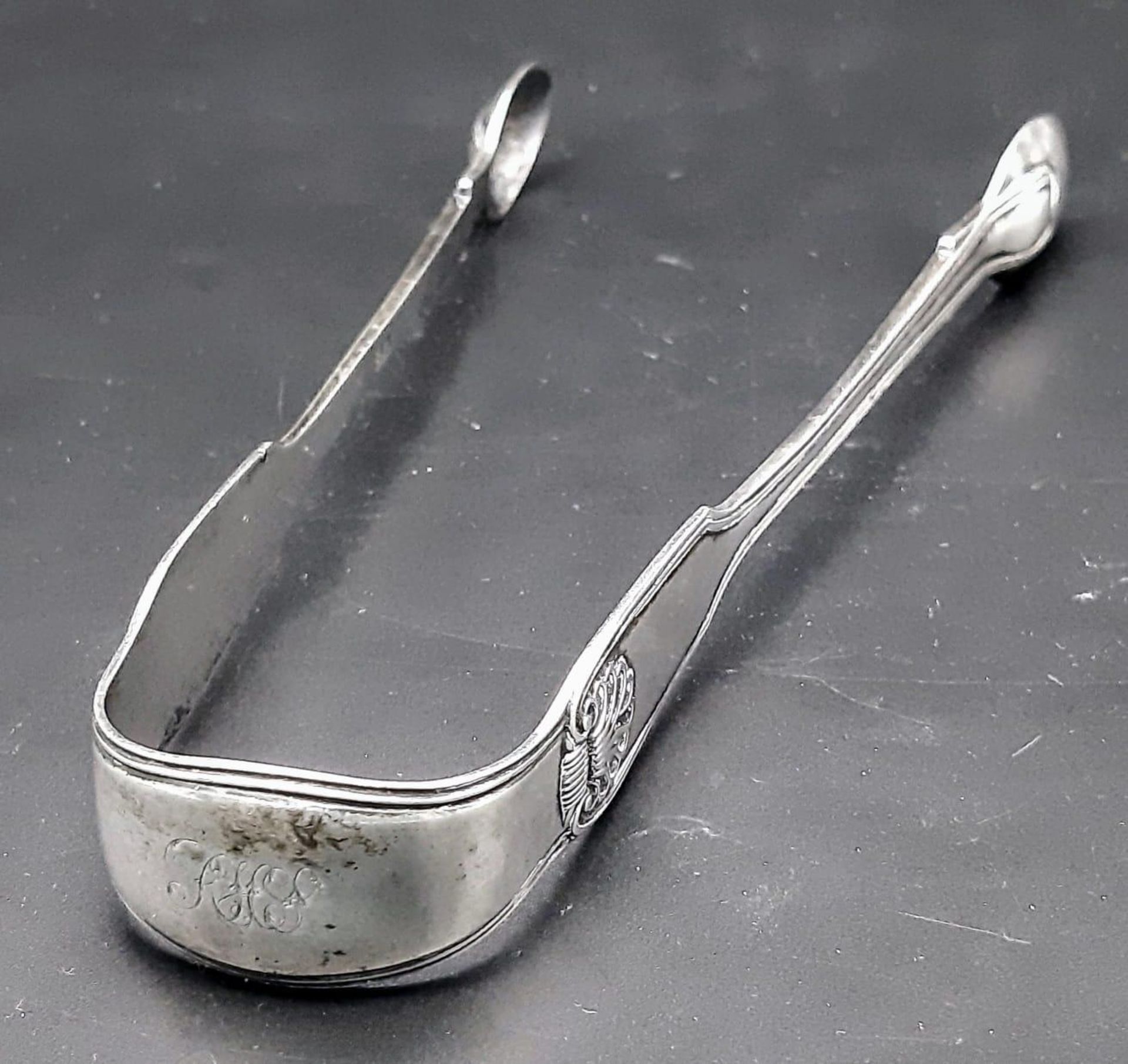 An antique Georgian sterling silver sugar tongs. Full hallmarks London, 1824. Total weight 52.6G. - Image 3 of 5