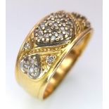 A Vintage 18K Yellow Gold Diamond Decorative Heart Ring. A central pave diamond heart with scrolls
