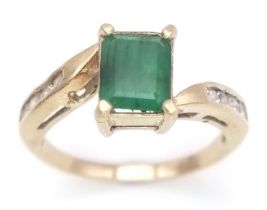 A 1ct EMERALD IN A 9K GOLD RING WITH WHITE SAPPHIRE SHOULDERS . 2.6gms size O