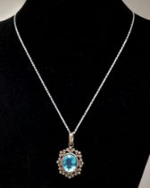 A Blue Topaz Pendant with Diamond Surround on 925 Silver and Silver Chain. 7.45ct topaz, 1.25ctw