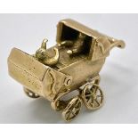 A 9K GOLD PRAM CHARM WITH MOVING PARTS . 4gms
