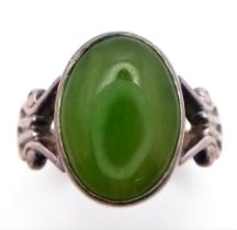 A vintage silver cabochon Jade solitaire ring with further decoration on shoulder. Total weight 4.