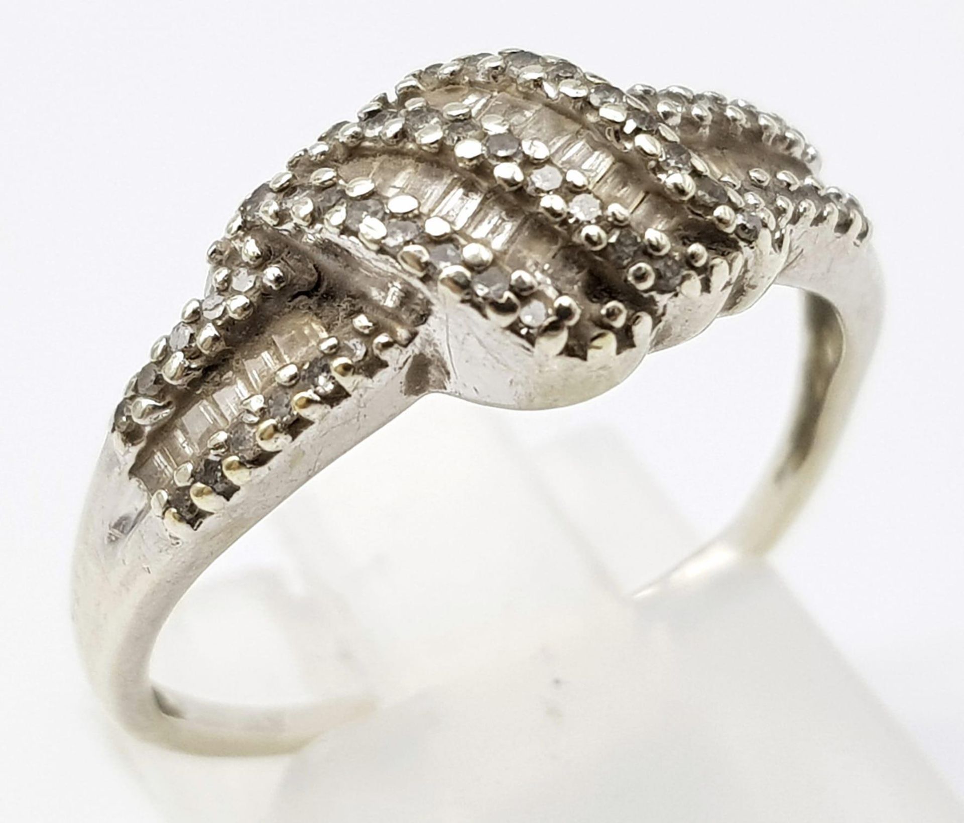 A 9K WHITE GOLD AND DIAMOND RING . 2.5gms size O