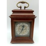 A "ROTHERHAM" CLOCKWORK MANTLE CLOCK WITH ORNATE SCROLLED METAL DIAL . ROMAN NUMERALS AND HOUSED
