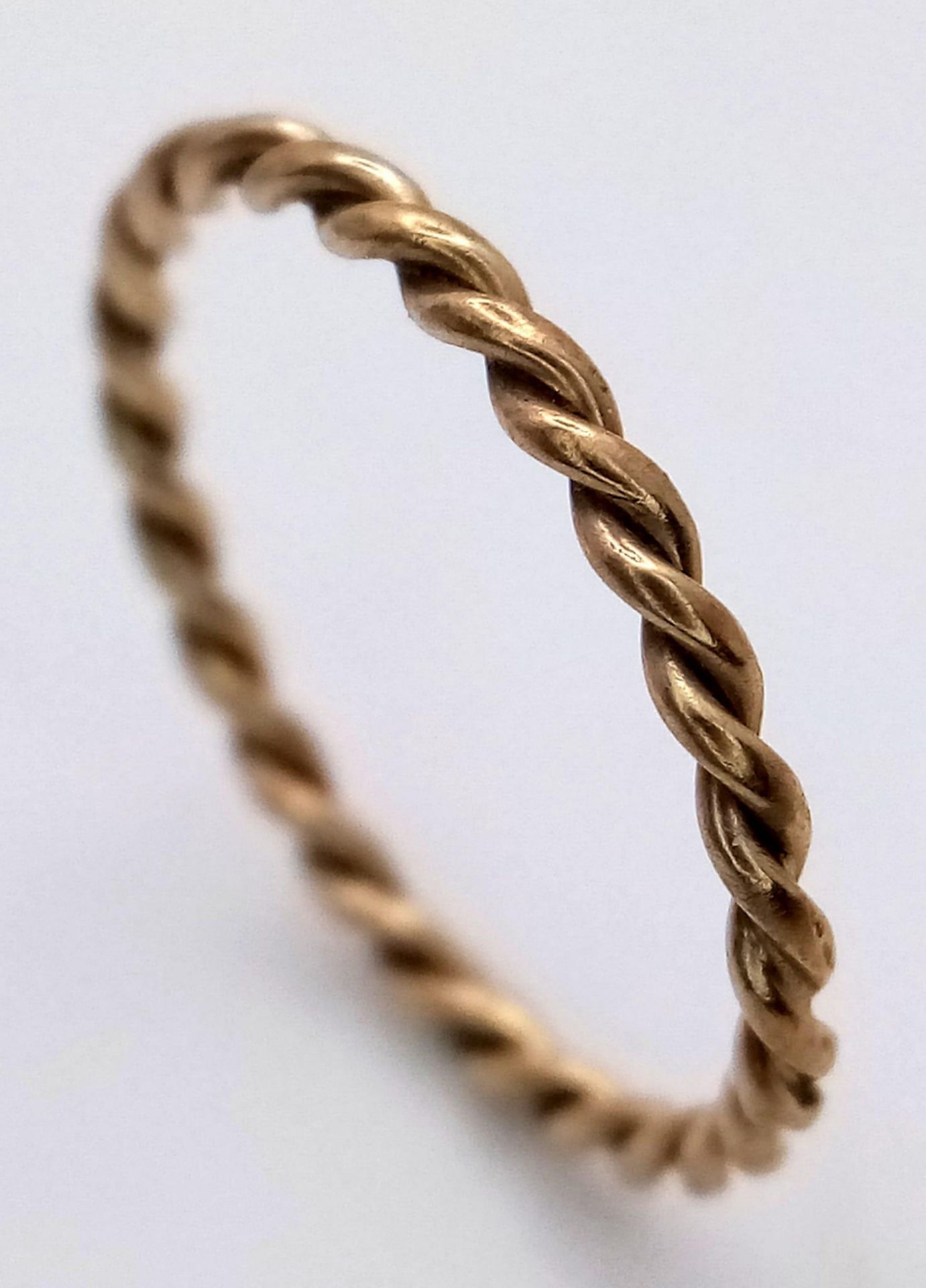 A 9K Yellow Gold Twist Band Ring. Size J 1/2. 0.7g