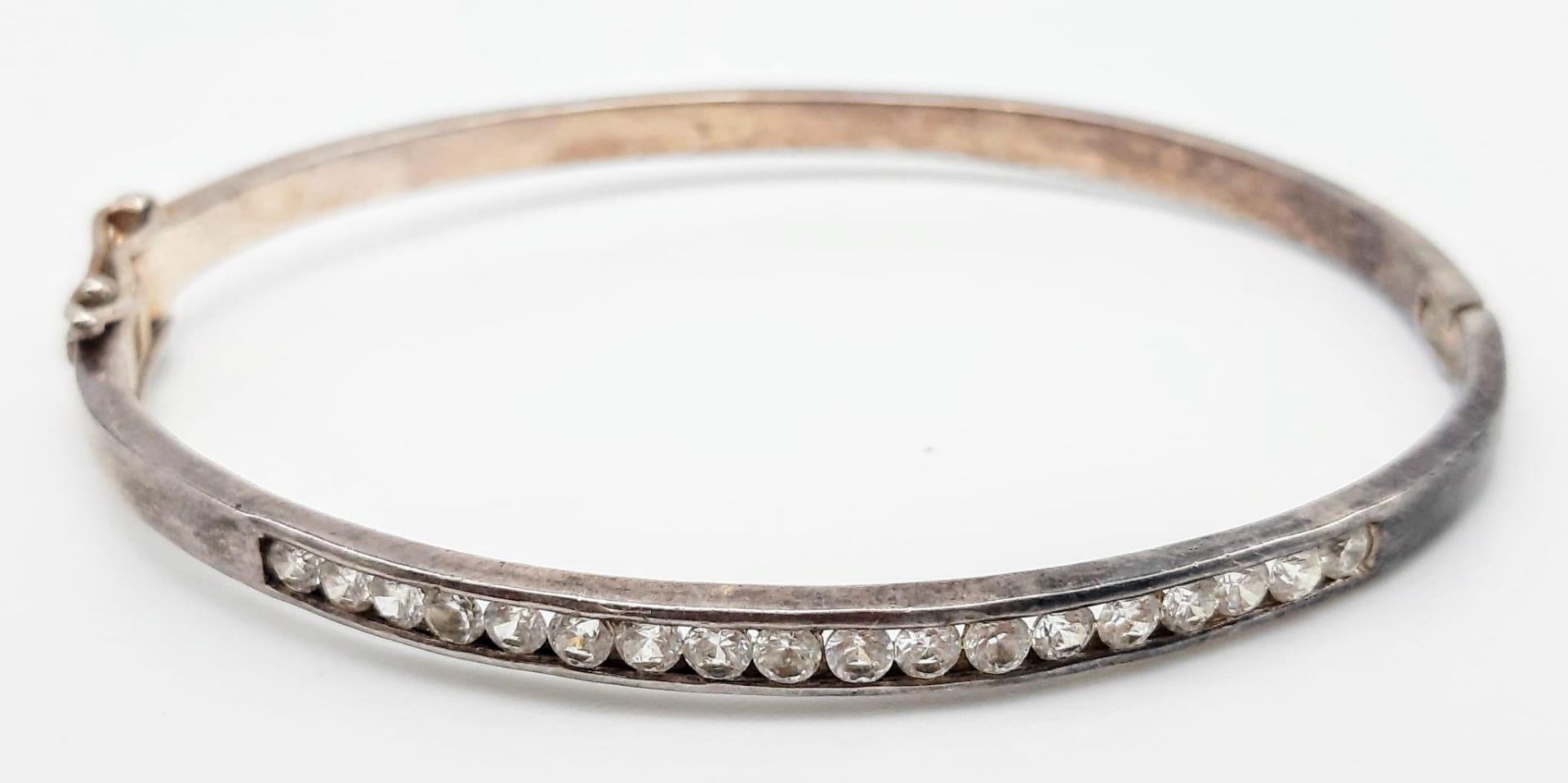 A vintage 925 silver stone set click-on bangle. Total weight 12.6G. Diameter 6.5cm.