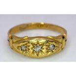 An Antique 18K Yellow Gold Three Stone Diamond Ring. Three bright white diamonds in star settings.