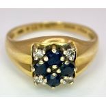 An 18K Yellow Gold Sapphire and Diamond Ring. A cross of four central sapphires with a diamond in