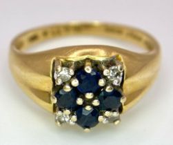An 18K Yellow Gold Sapphire and Diamond Ring. A cross of four central sapphires with a diamond in