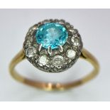 An 18K Yellow Gold Aquamarine and Diamond Ring. Sky blue aquamarine with a diamond halo. Size K. 2.