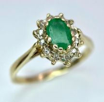 A 9K GOLD EMERALD AND DIAMOND CLUSTER RING . 1.8gms size M