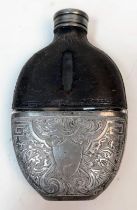AN ANTIQUE HIP FLASK WITH REMOVABLE CUP REVEALING A GLASS BOTTOM AND HAVING LEATHER SHOULDERS AND